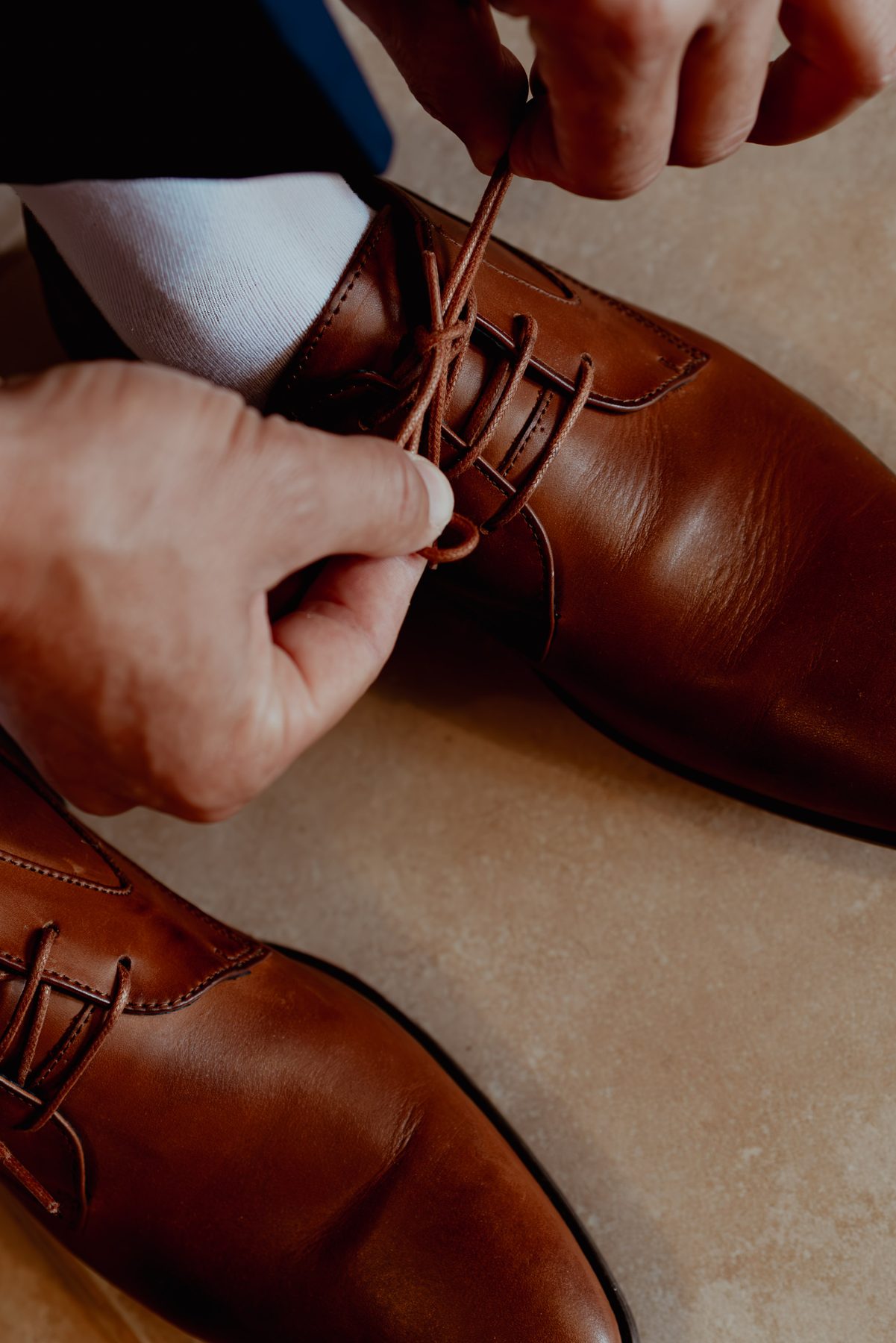 Mariage — le marié laçant ses chaussures