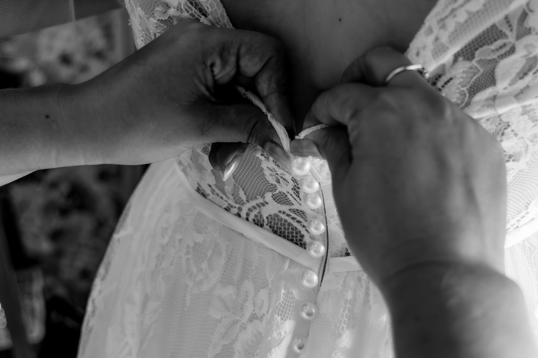 Mariage — boutonnage de la robe de la mariée, noir et blanc